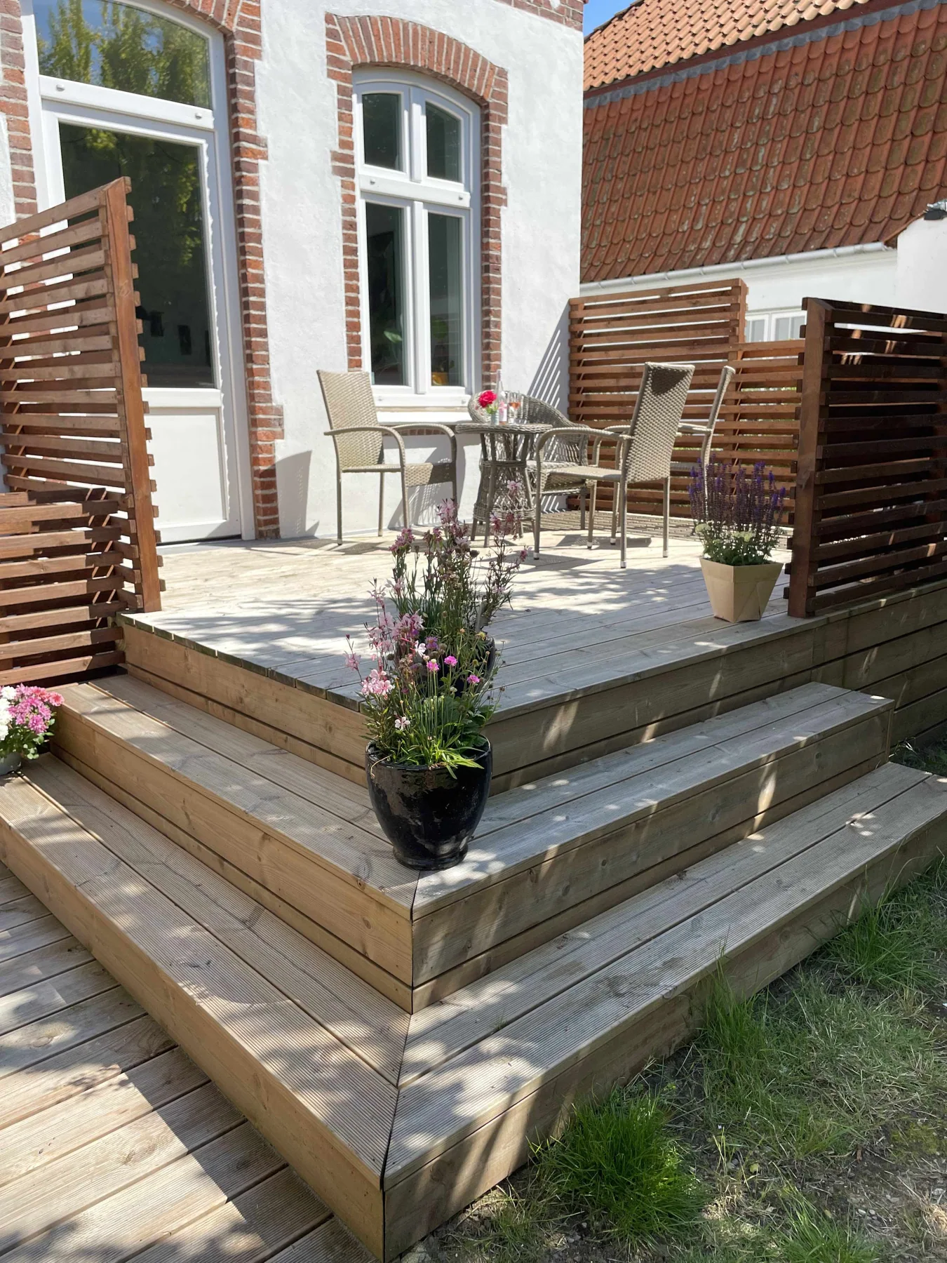 Terrassen med trætrapper og blomster